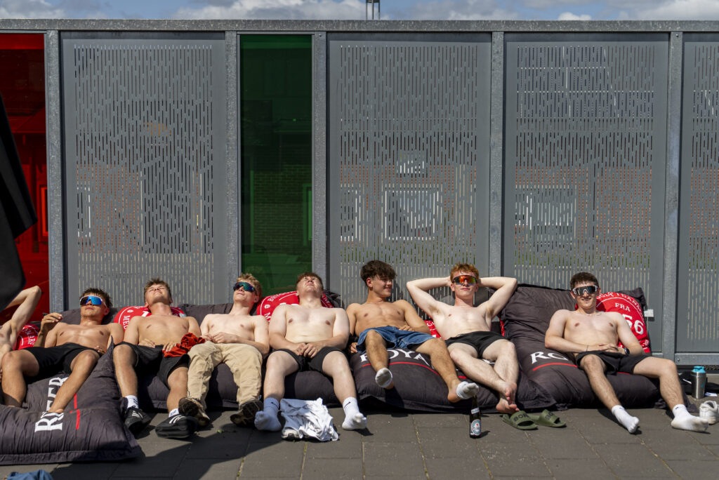 Elever, der slikker sol ved poolen i sommeren